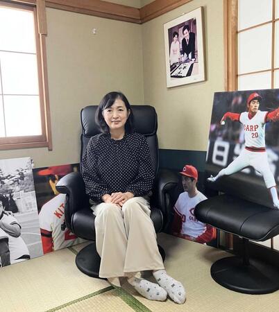 　北別府さんの写真に囲まれ、子どもたちが北別府さんに贈った椅子に座る広美さん
