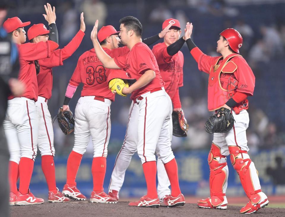 　延長戦の末にロッテに競り勝ちタッチを交わす中崎（右から３人目）ら広島ナイン（撮影・開出牧）