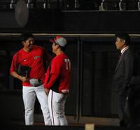 　試合前練習中に談笑する野間（左）と緒方元監督（右）