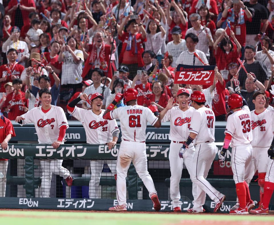 　６回、左越え満塁弾を放ち、チームメートに出迎えられるファビアン（撮影・市尻達拡）