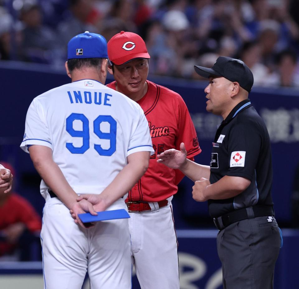 　メンバー表を交換後、審判団から何らかの説明を受ける新井監督と井上監督（撮影・市尻達拡）