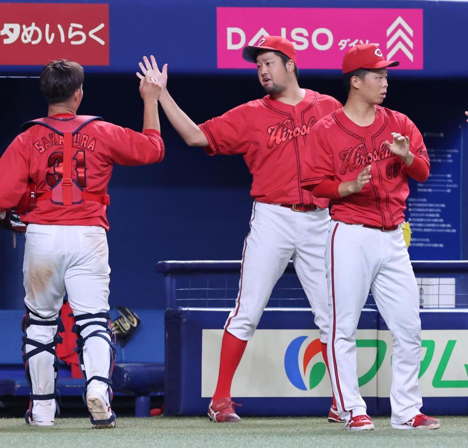 　６回、ピンチをしのぎ、坂倉とタッチを交わす中崎（撮影・市尻達拡）