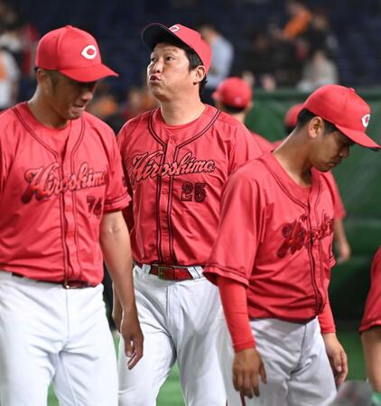 　延長戦で巨人と引き分け０が並ぶスコアボードを見つめる新井監督（中央）＝撮影・開出牧