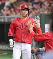 　６回、同点の左越えソロを放ちナインとタッチを交わす中村奨（撮影・開出牧）