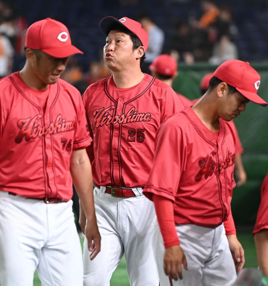 　延長戦で巨人と引き分け０が並ぶスコアボードを見つめる新井監督（中央）＝撮影・開出牧