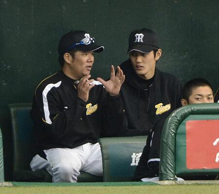 　ベンチで藤井彰（左）からアドバイスされる藤浪＝２０１３年３月