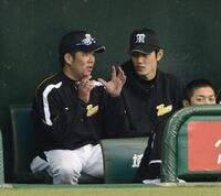 　ベンチで藤井彰（左）からアドバイスされる藤浪＝２０１３年３月
