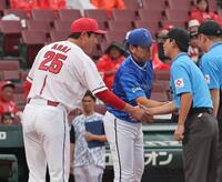 　審判団と握手をする新井監督と三浦監督（撮影・市尻達拡）