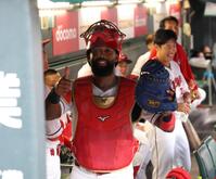 　降雨中断中、捕手の防具をつけ、石原のモノマネをしてチームを和ませるファビアン（撮影・市尻達拡）