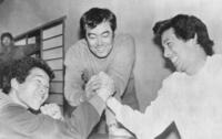 川口和久（右）と津田恒美（左）の腕相撲審判をする広島・安仁屋宗八コーチ＝１９８３（昭和５８）年１１月当時、敬称略