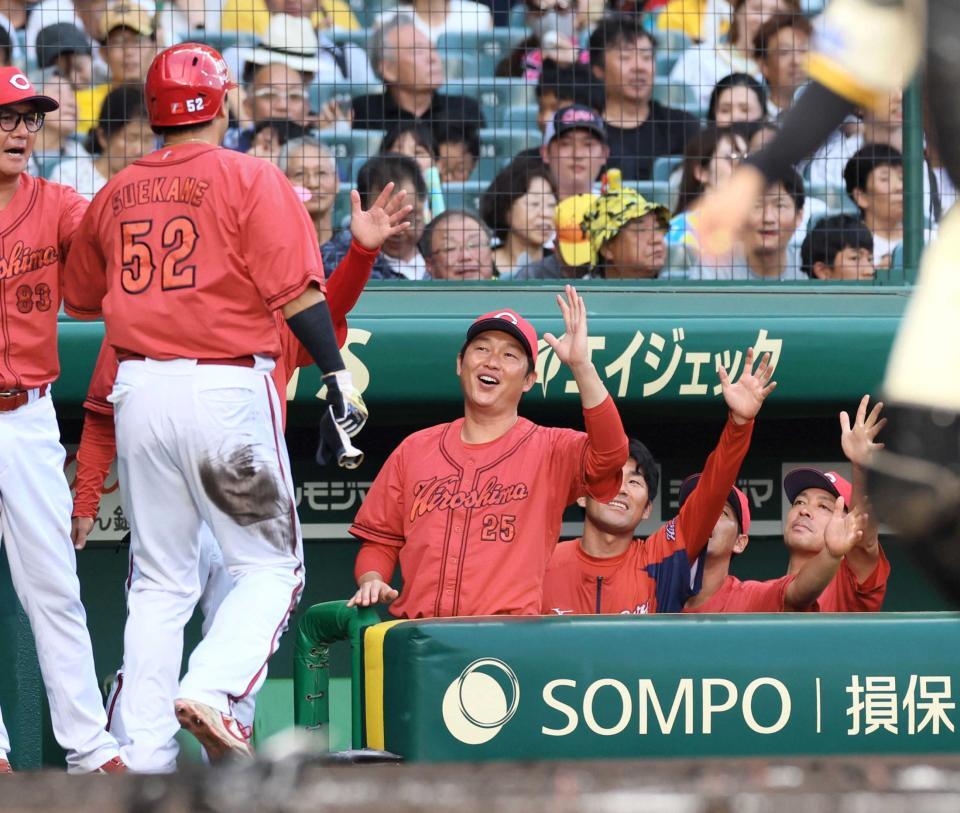 　生還した末包（５２）を迎える新井監督（中央）＝撮影・立川洋一郎