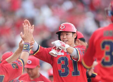 　１回、左中間へのタイムリー二塁打を放ち、笑顔でタッチを交わす坂倉（撮影・市尻達拡）