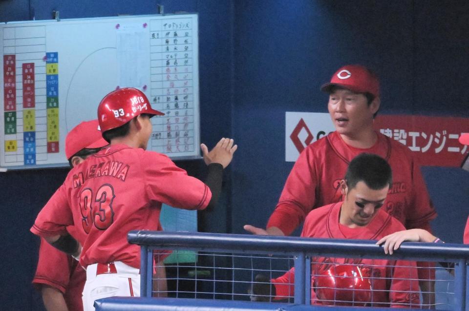 　２回　ベンチに戻り新井監督（右）とタッチする前川