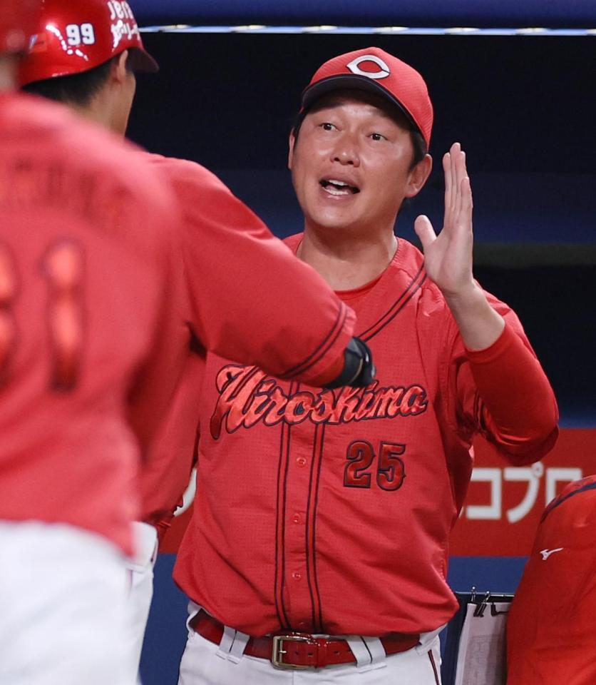 　２回、生還した二俣をベンチで迎える新井監督