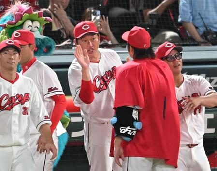 　ハイタッチでナインを迎える新井監督（撮影・飯室逸平）