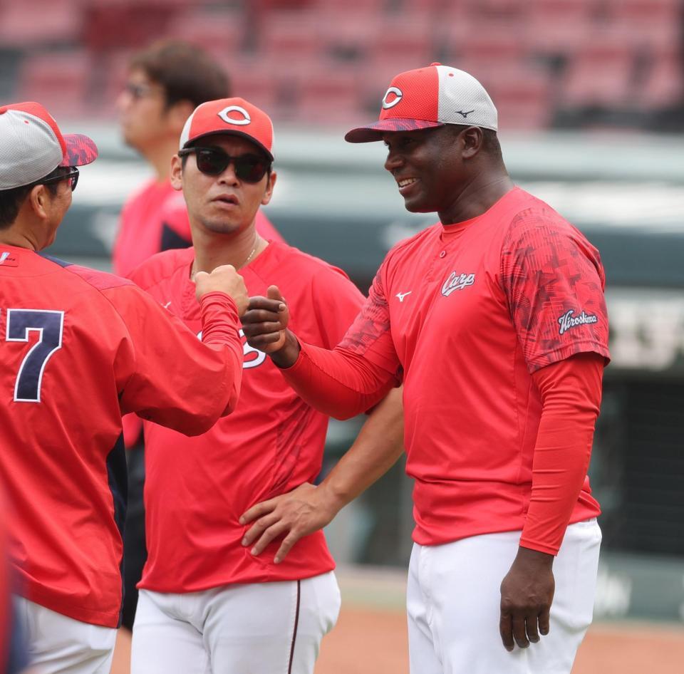 　チームに合流し、藤井ヘッドコーチ（左手前）とグータッチをするクレート通訳（右）＝撮影・市尻達拡