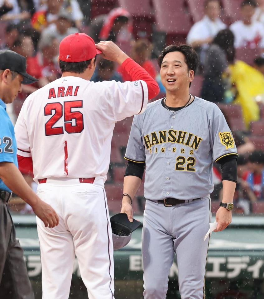 　メンバー表交換時に、言葉を交わす藤川監督と新井監督（撮影・市尻達拡）