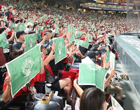 　５回を終え、平和を祈り、緑のポスターを掲げるファン（撮影・市尻達拡）