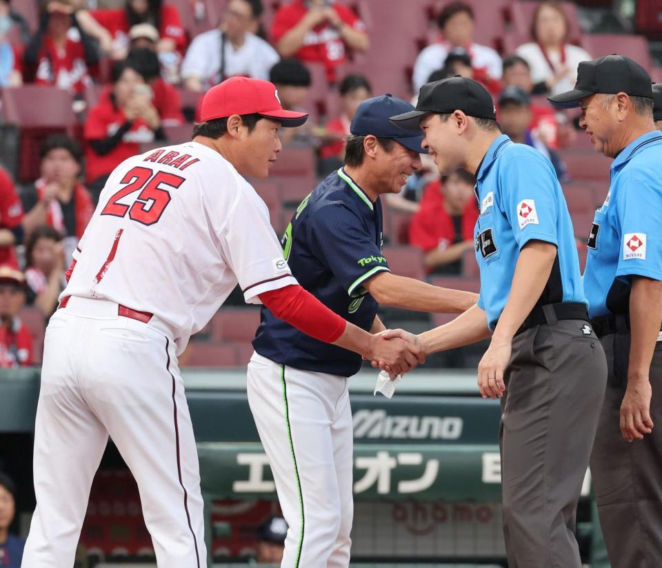 　メンバー表を交換し、審判団と握手をする新井監督と高津監督（撮影・市尻達拡）