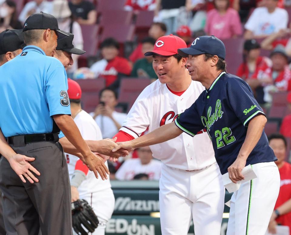 　審判団と握手する新井監督と高津監督（撮影・市尻達拡）