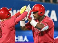 　９回、勝ち越し２ランを放ち、一走羽月（左）とタッチを交わすモンテロ