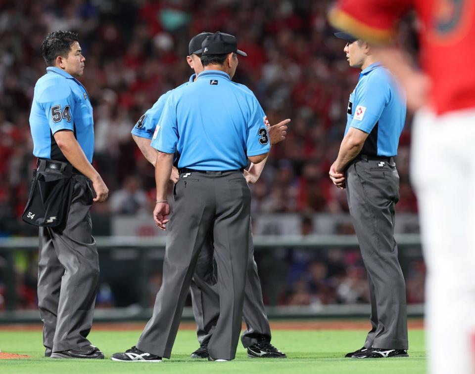 　８回、小園の中飛か中前打を巡って、話をする審判団（撮影・市尻達拡）