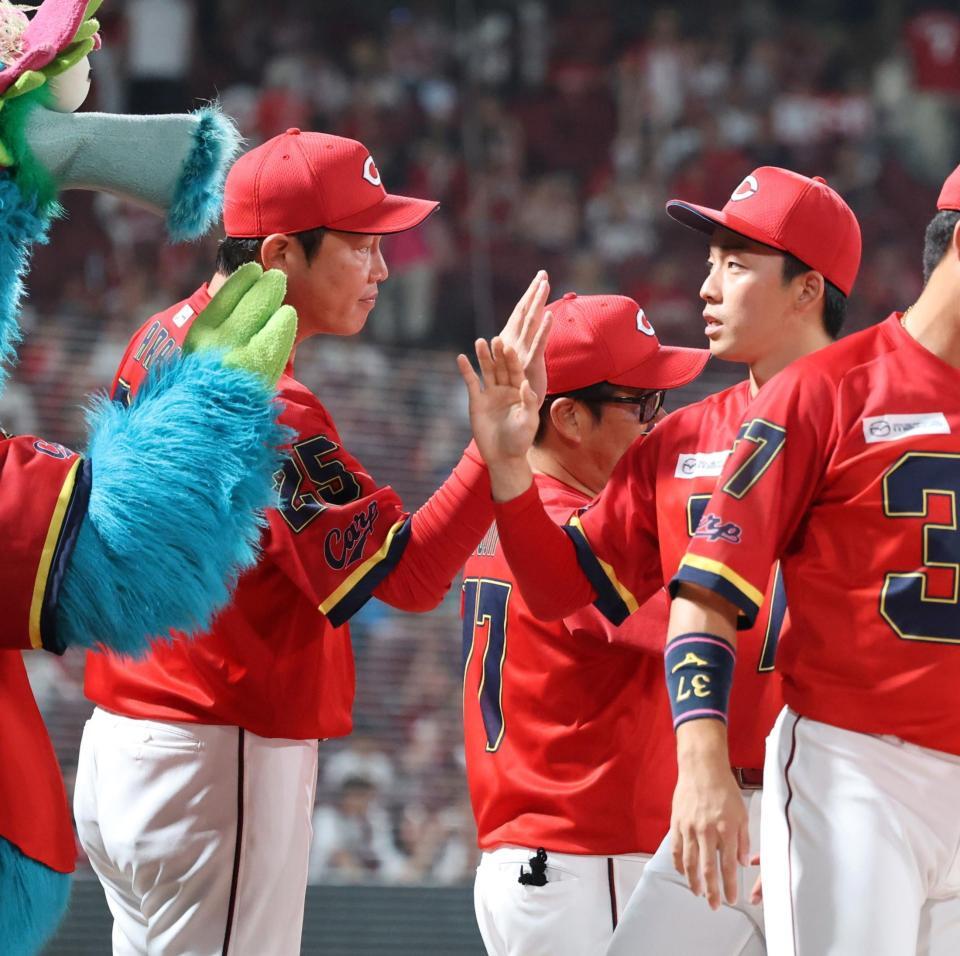 　今季初勝利を手にした常広とタッチを交わす新井監督（撮影・市尻達拡）