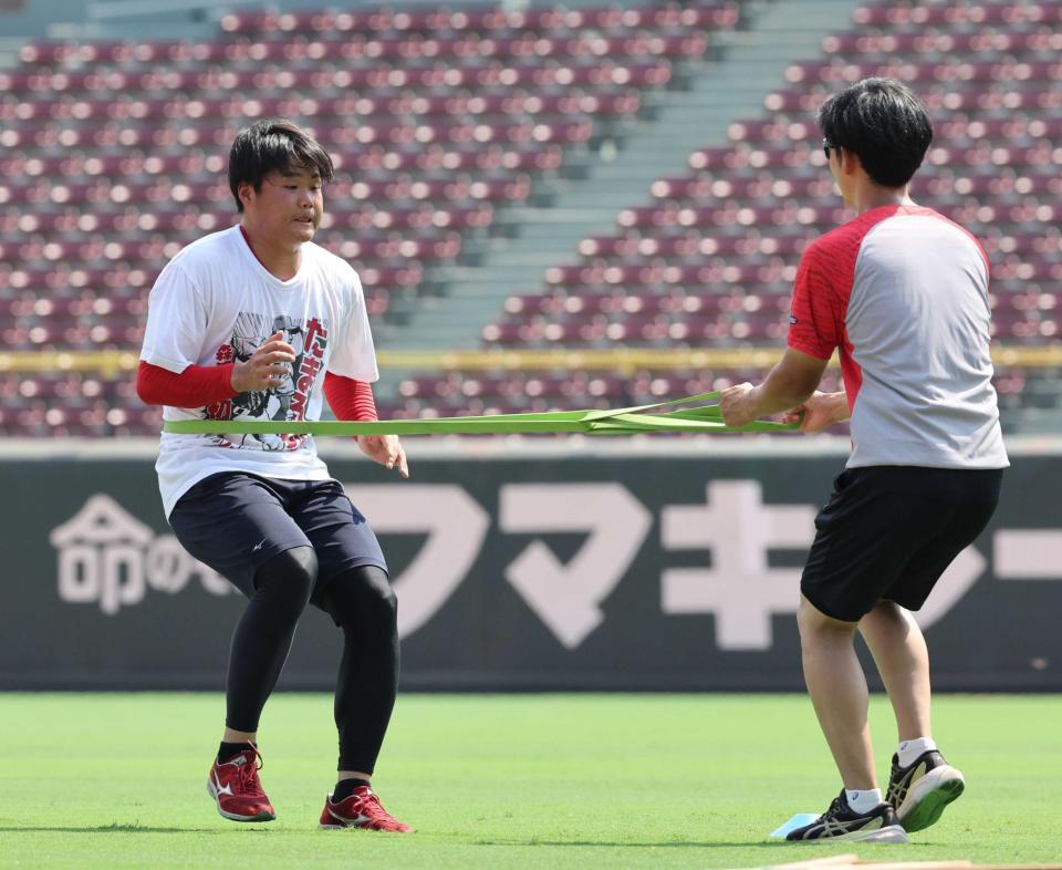 　ゴムチューブを体に巻き、トレーニングをする高（撮影・市尻達拡）