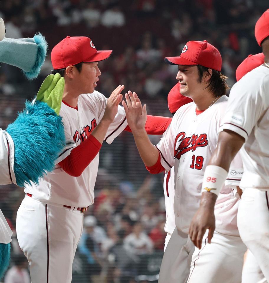 　完投勝利し、新井監督とタッチを交わす床田（撮影・市尻達拡）