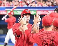 　ナインに迎えられる坂倉（撮影・園田高夫）