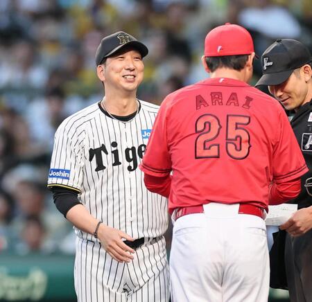 　試合前、新井監督とメンバー表の確認をし、笑顔を見せる藤川監督（撮影・田中太一）