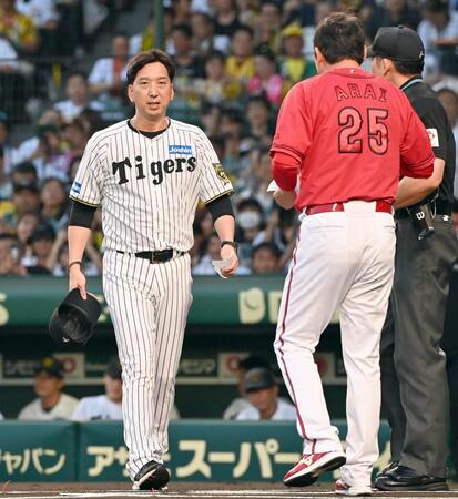 　試合前、メンバー表の交換をする新井監督（右）と藤川監督