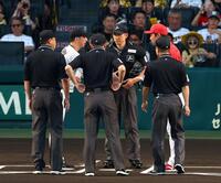 　メンバー表を交換し握手する藤川監督と新井監督（撮影・山口登）