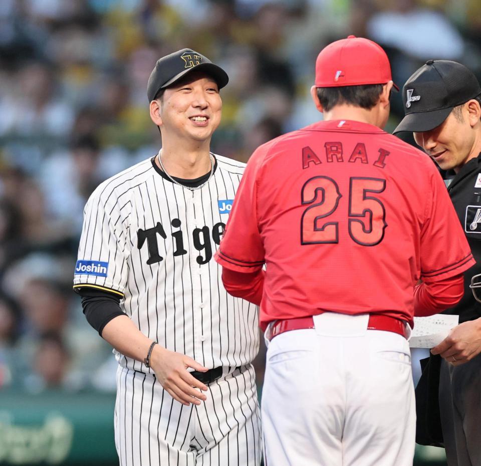 　試合前、新井監督とメンバー表の確認をし、笑顔を見せる藤川監督（撮影・田中太一）