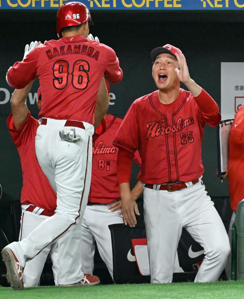 　９回表、勝ち越しソロを放った中村奨（左）を迎える新井監督