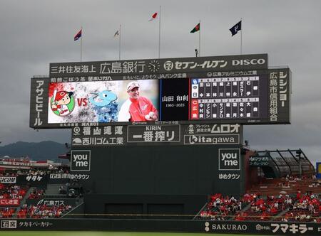 　故・山田和利さんをしのび、現役時代などの活躍が映し出されるスコアボード（撮影・市尻達拡）
