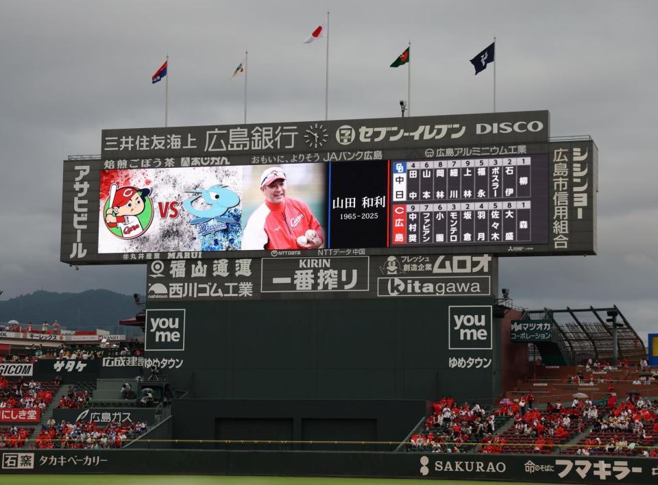 　故・山田和利さんをしのび、現役時代などの活躍が映し出されるスコアボード（撮影・市尻達拡）