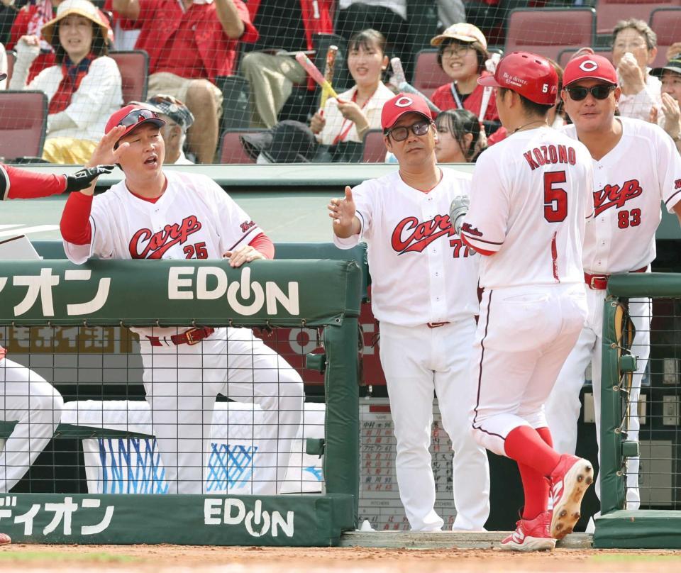 　１回、生還した小園（５）を迎える新井監督（左）＝撮影・市尻達拡