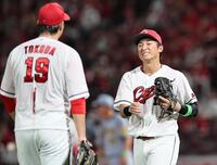 　６回、中川の打球を一塁へ悪送球し、床田（左）に謝る佐々木（撮影・田中太一）