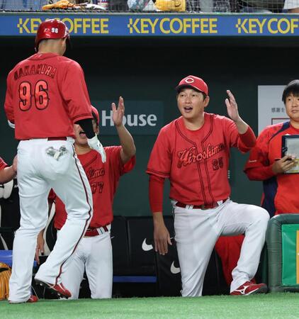 　４回、本塁打を放った中村奨を迎える新井監督