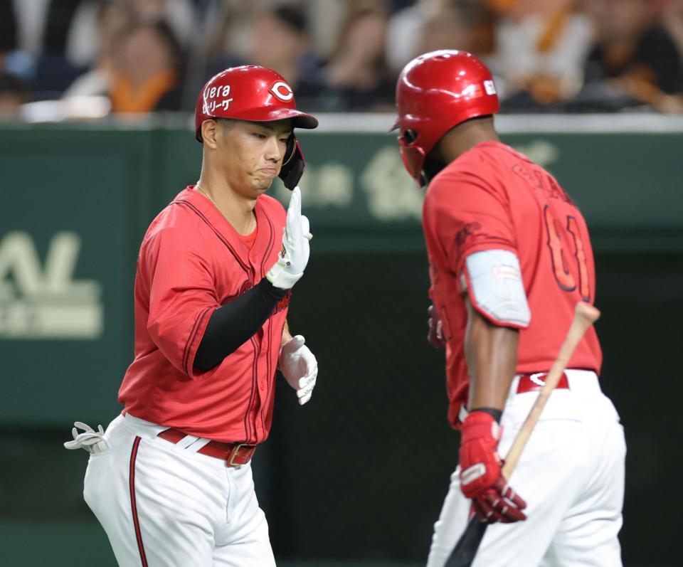 　４回、同点ソロを放ち、ファビアン（右）とタッチを交わす中村奨（撮影・西岡正）