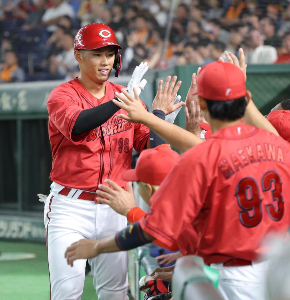 　４回、同点ソロを放ち、ナインとタッチを交わす中村奨（撮影・西岡正）