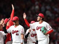 　プロ初登板で試合を締め、伸ばした小園の手にタッチをする菊地（撮影・市尻達拡）