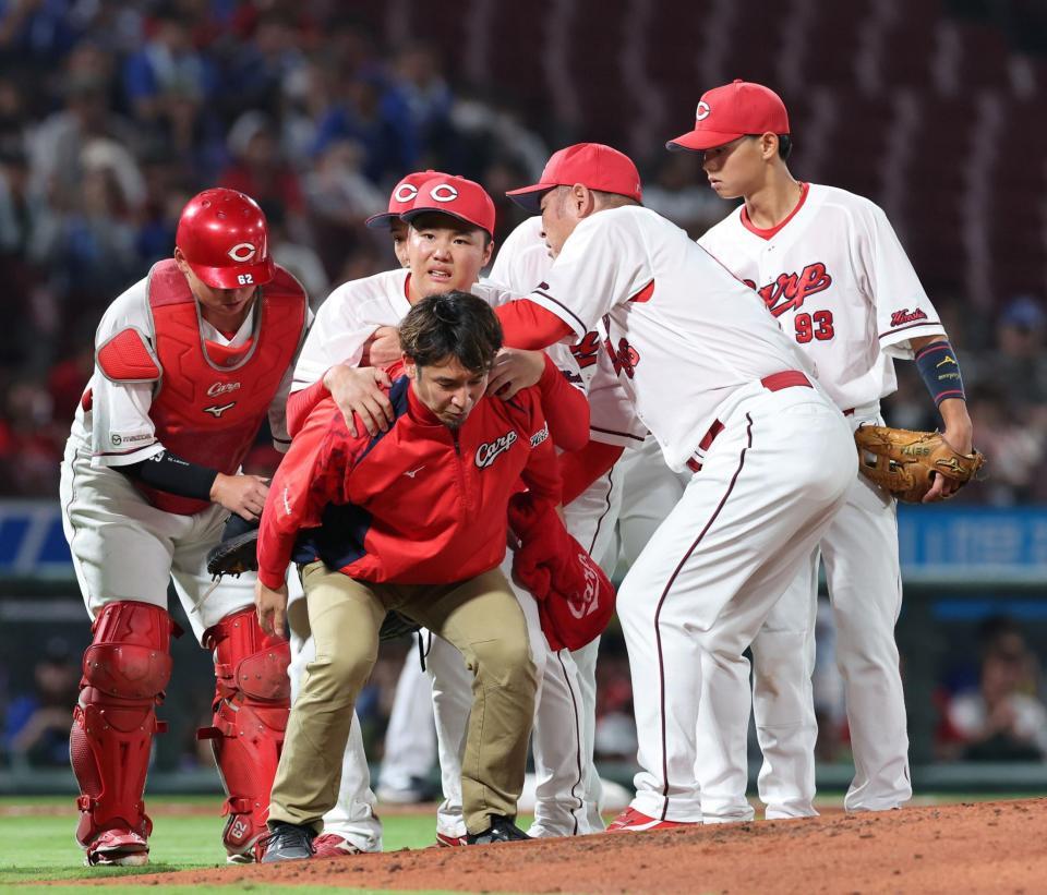 　３回、ビシエドの打球が右足首付近に当たり、トレーナーに背負われ、治療のためベンチ裏に下がる高（撮影・市尻達拡）
