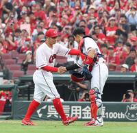 　９回の守備で交代を告げられ、石原と握手をする田中（撮影・市尻達拡）