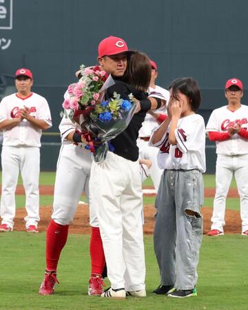 　家族から花束を受け取り、涙を流して感謝を伝える上本（撮影・市尻達拡）