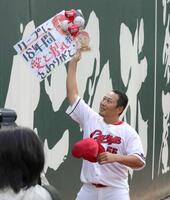 　ファンから感謝の言葉が記されたボードを受け取る松山