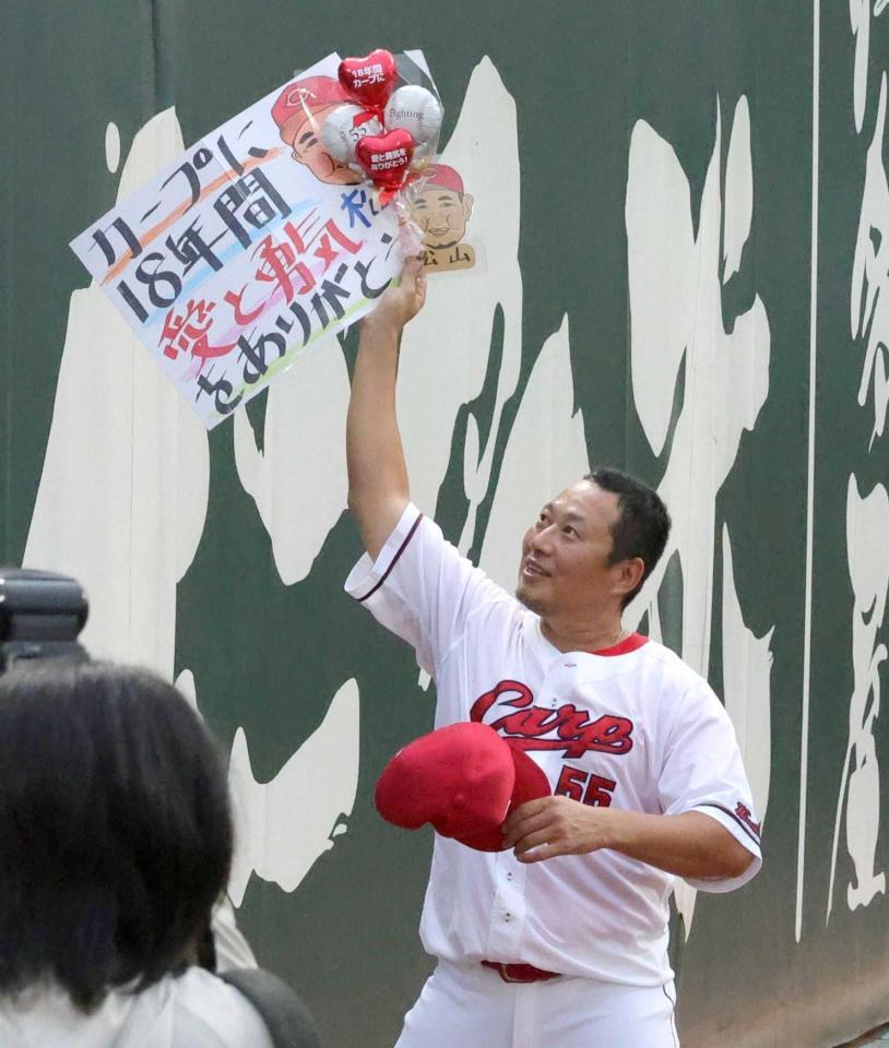 　ファンから感謝の言葉が記されたボードを受け取る松山