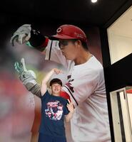 　巨大ポスターと同じポーズをとる小園（撮影・市尻達拡）