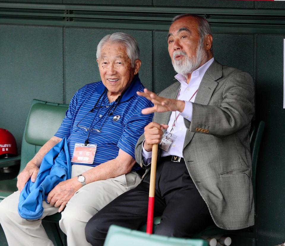 　マツダスタジアムのベンチでフィーバー平山氏（左）と談笑する安仁屋氏＝２０１５年４月